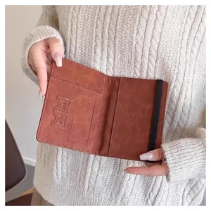Porta pasaporte de cuero PU marron organizador de viaje con ranuras y banda elastica.