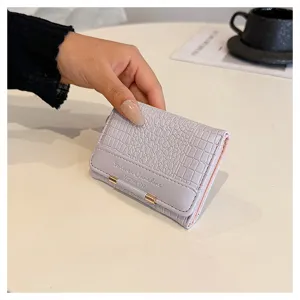 Detailansicht der kurzen PU-Lederbrieftasche mit schickem Kroko-Muster und Metallverschluss.