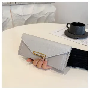 Close-up detail of the grey long wallet featuring chic envelope flap and sleek metal clasp.
