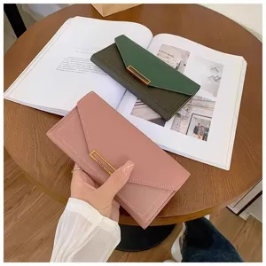 Close-up detail of women's long folding envelope wallet in pink and green with sleek metal clasp.