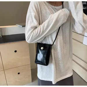Chic black crossbody phone bag for women with pearl detail, lightweight and stylish summer use.