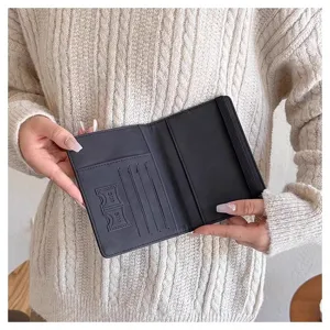 Primer plano del interior del portapasaportes negro, mostrando ranuras y bolsillos SIM.