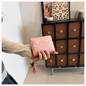 Detailed view of the cute pink PU leather short wallet with cat graphic and tassel.