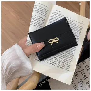 Chic black short wallet featuring a cute gold bowknot hardware, compact and stylish detail view.