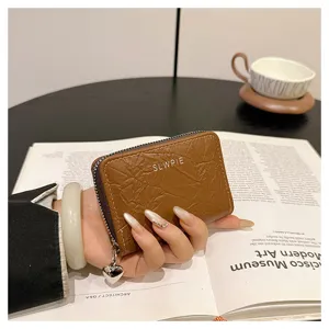 Close-up of brown wrinkled leather card wallet with heart zipper pull and compact slots.