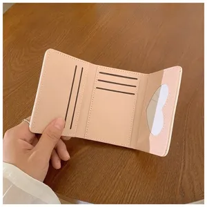 Portafoglio compatto a tre ante con utili fessure per carte e graziosa finestra a cuore.