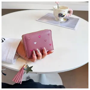 Detailed shot of a cute pink short PU leather wallet with embroidered hearts, tassel charm.