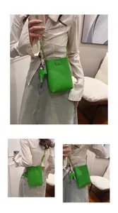 Green mini phone bag with cute elephant charm, stylish crossbody strap and compact design details.