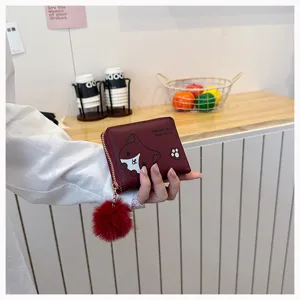 Vista dettagliata del portafoglio corto da donna con simpatico design animale e pompon in peluche.