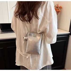Detail view of a stylish silver mini crossbody phone bag with cute elephant charm.