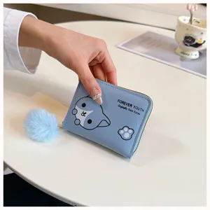 Primo piano dettagliato di un piccolo portafoglio con cerniera e pon-pon soffice.