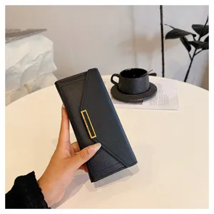 Elegant black long envelope wallet for women featuring a chic gold tone metal bar closure.
