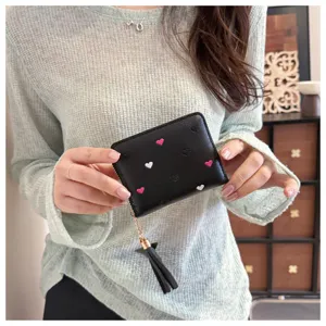Close-up detail of a cute black PU leather short wallet featuring lovely heart embroidery and stylish tassel.
