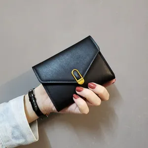 Close-up view of a chic black short folding women wallet with a golden metal clasp detail.