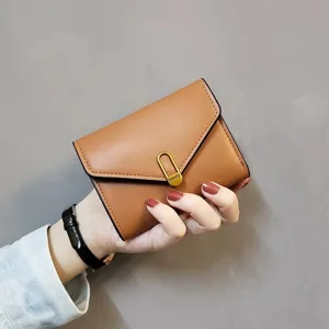 Detail view of a stylish brown short folding women's wallet with metal clasp and card slots.