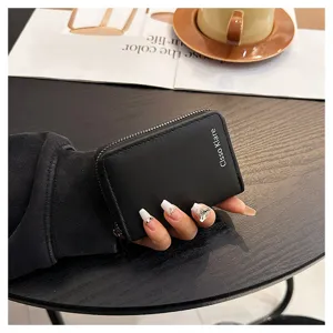 Compact black leather card case with zipper closure, multi-slot capacity, minimalist style.