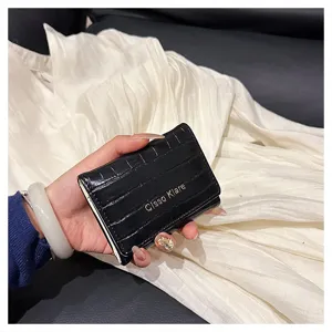 Vue détail de petit portefeuille pliant noir motif crocodile, porte-cartes compact.