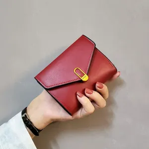 Red women short folding wallet detail view, compact leather card holder and coin purse design.