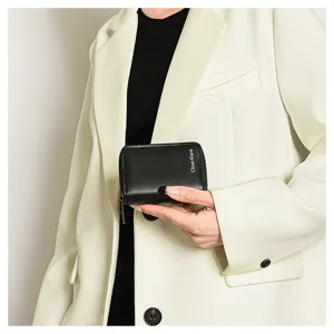 Black leather card holder detail, compact multi-card slot wallet with secure zipper closure.