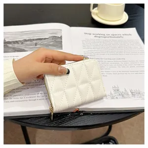 White quilted card holder detail shot showing zipper closure and compact accordion card slots design.
