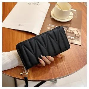 Detailed shot of black quilted long wallet with zipper and wrist strap on wooden table.