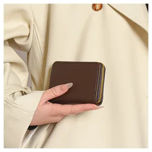 Vue détaillée d'un porte-cartes en cuir PU marron foncé, montrant une fermeture éclair lisse et pratique.