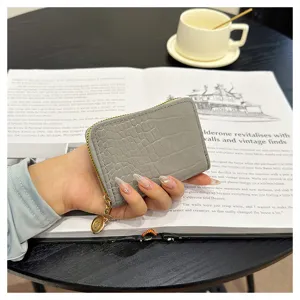 Detail shot of grey crocodile pattern coin purse zipper card wallet on coffee table book.