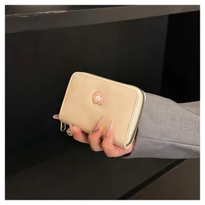 Primo piano dettaglio del portafoglio carte con zip satinato e carino per donna con stemma.