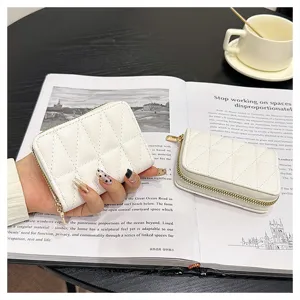 Close-up of white quilted accordion card holder featuring secure zipper closure and compact design.