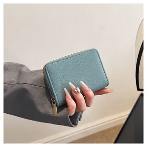 Porte-cartes compact en cuir PU bleu, vue de detail montrant la fermeture eclair et texture.