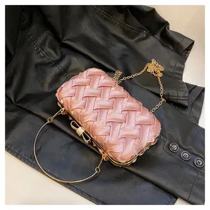 Dettaglio della borsa da sera intrecciata rosa con elegante montatura dorata e fiocco.