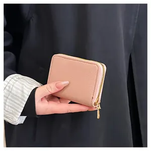 Gros plan d'un compact portefeuille en cuir PU rose avec fermeture dores pour cartes.