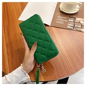 Green quilted long wallet for women with zipper closure, wrist strap and clover charm chic.