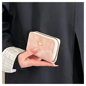 Primo piano del mini portacarte rosa con zip che mostra la sua delicata trama opaca.
