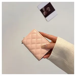Pink quilted leather zipper card holder detail, compact accordion card case close-up view.