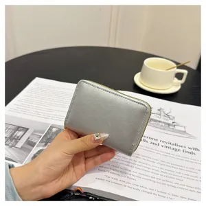 Silver PU leather coin purse close-up, compact zipper card holder with multiple inner slots.