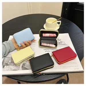 Women's minimalist multi-slot card holder wallet with secure zipper closure design.
