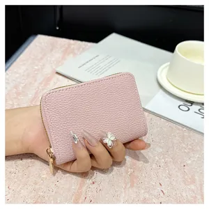 Monedero tarjetero con cremallera de cuero texturizado rosa, vista de detalle elegante.