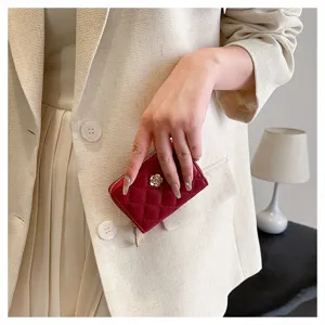 Portacarte trapuntato rosso con elegante dettaglio di camelia, piccolo portamonete con zip da donna.