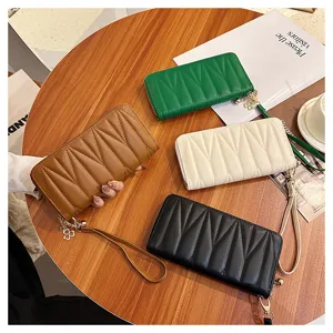 Women's long quilted wallet PU leather clutch purse with wrist strap and clover charm.