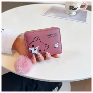 Primo piano del portafoglio corto rosa con motivo di gatto, chiusura lampo e pompon soffice.