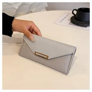 Detail shot of a minimalist grey long envelope wallet held in hand, showing fine texture.