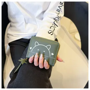 Detailed view of green PU leather short coin purse with cute cat graphic and star tassel.