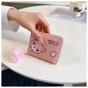 Dettaglio del grazioso portafoglio rosa corto con stampa di animali e pompon soffice.