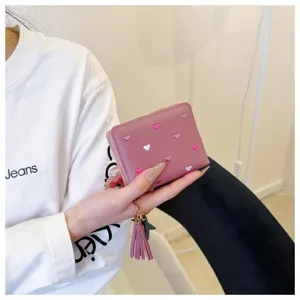 Pink PU leather short wallet with cute heart embroidery and tassel charm detail close up view.