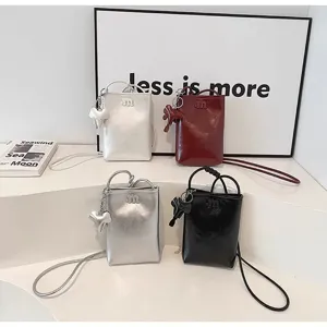 Women mini leather crossbody phone bag with cute elephant pendant and shoulder strap.