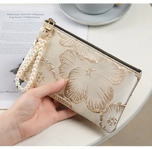 Elegant embroidered pearl clutch wallet for women, stylish long zipper phone storage bag.