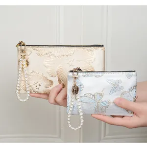 Chinese style embroidered coin purse with elegant pearl wrist strap and secure zipper closure.