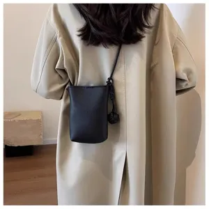 Vue détaillée d'un élégant mini sac bandoulière de téléphone noir en cuir PU avec nœud.