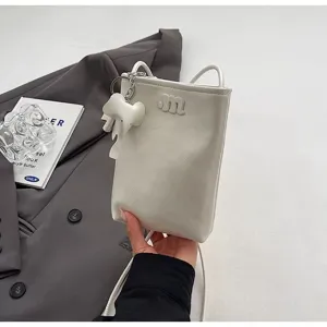 Detailed view of white mini phone crossbody bag with cute elephant charm and letter m design.